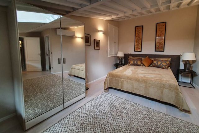 armadio Tomasella con ante a specchio installato in una camera da letto moderna a Lucca.