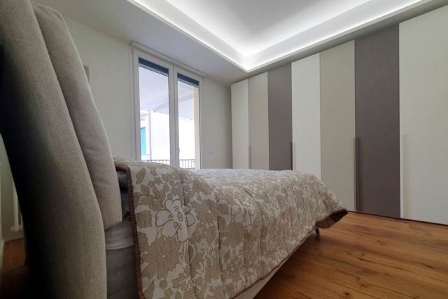 Camera matrimoniale moderna realizzata a Viareggfio con letto contenitore e armadio a battente