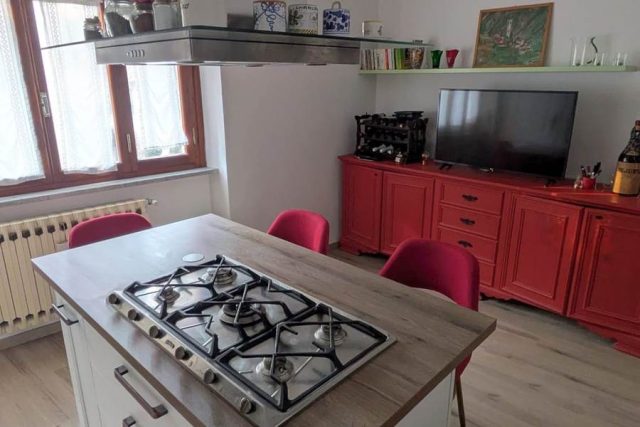 Credenza restaurata di colore rosso, sgabelli tessuto rosso