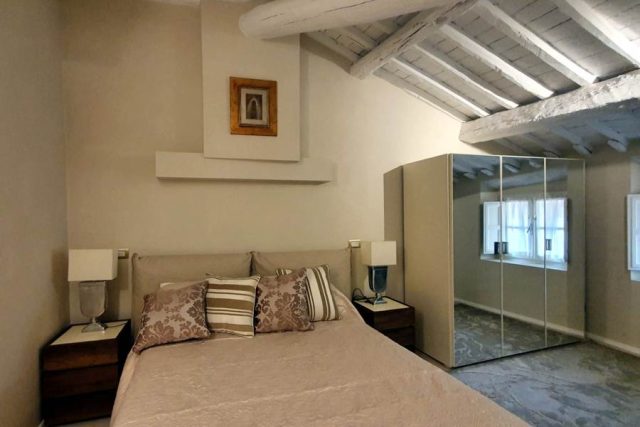 Camera da letto con armadio su misura ante a specchio, letto imbottito.